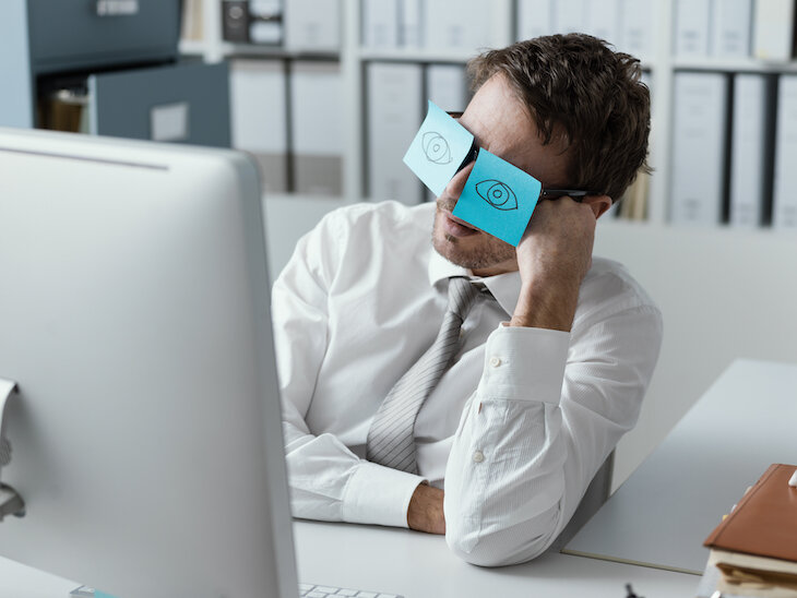 office employee with post-its on eyes